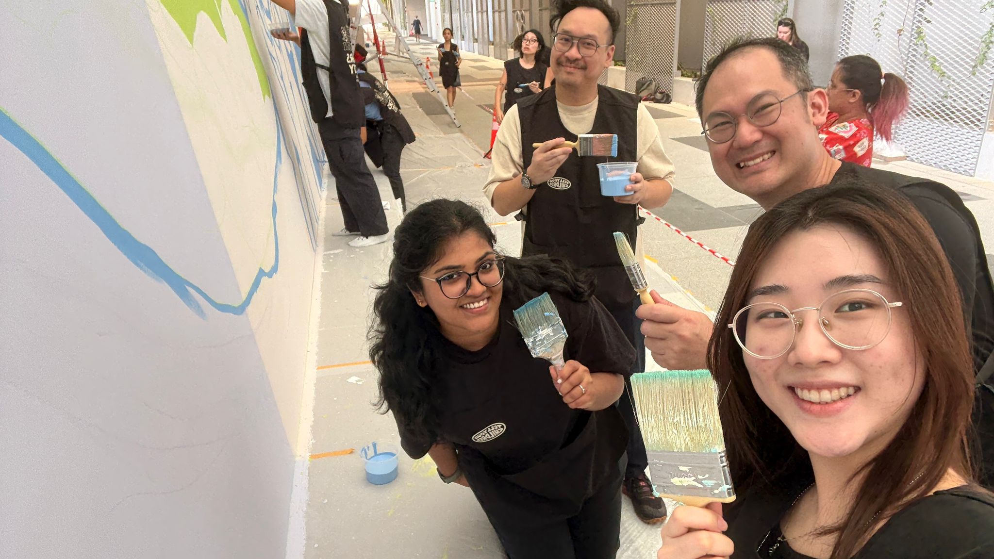 Behind the scenes photo of final mural finishing touches